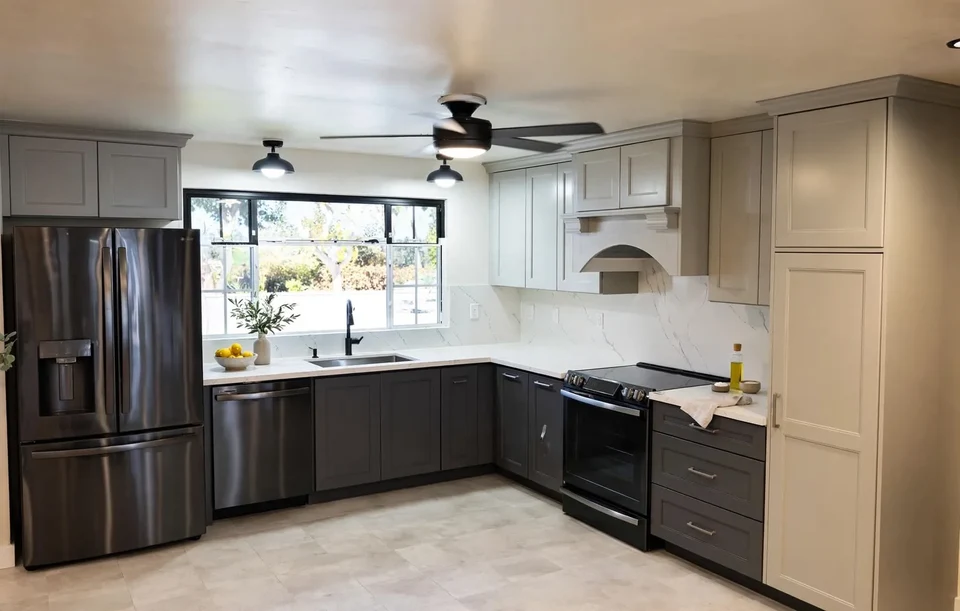 Kitchen with pale upper cabinetry, dark lower cabinets, a window above the sink, and a stainless steel refrigerator.