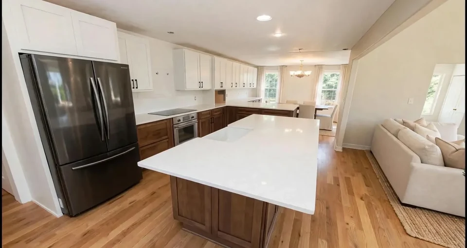 Kitchen with a wood-grain island, white countertops, and a black refrigerator.